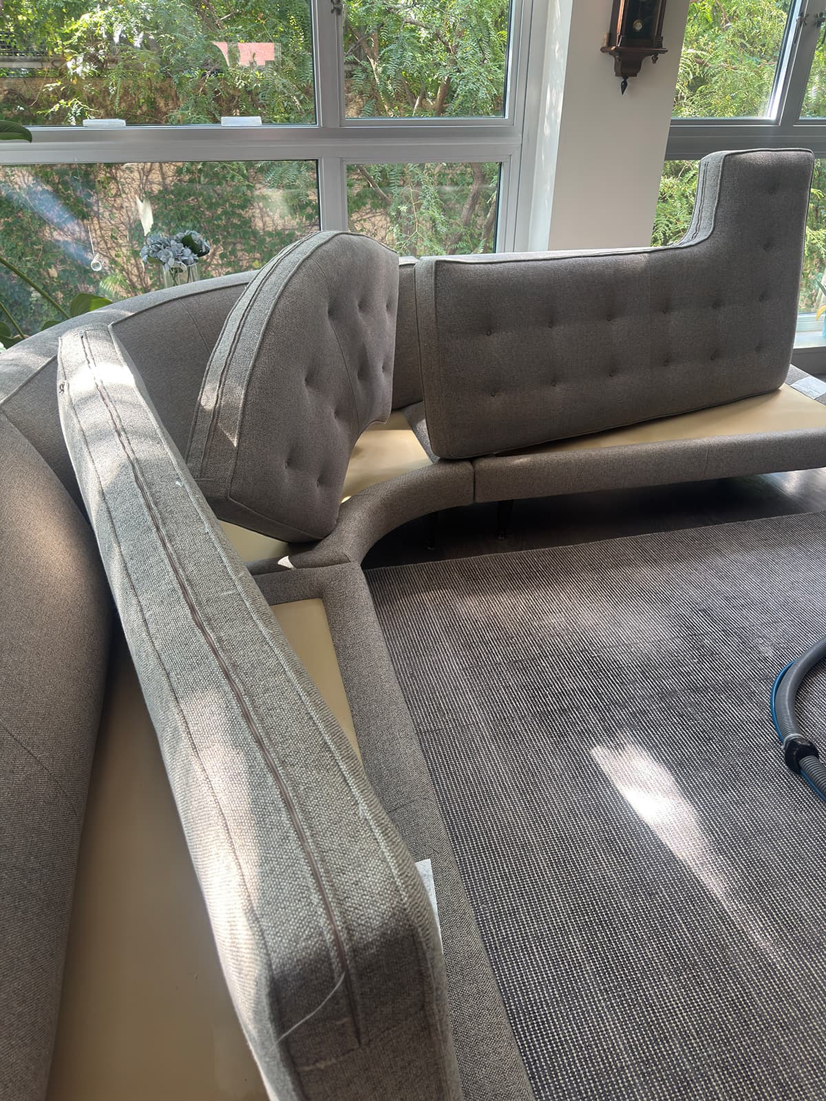Cushions lifted clear of a tufted banquette so the frame and seat deck can be cleaned
