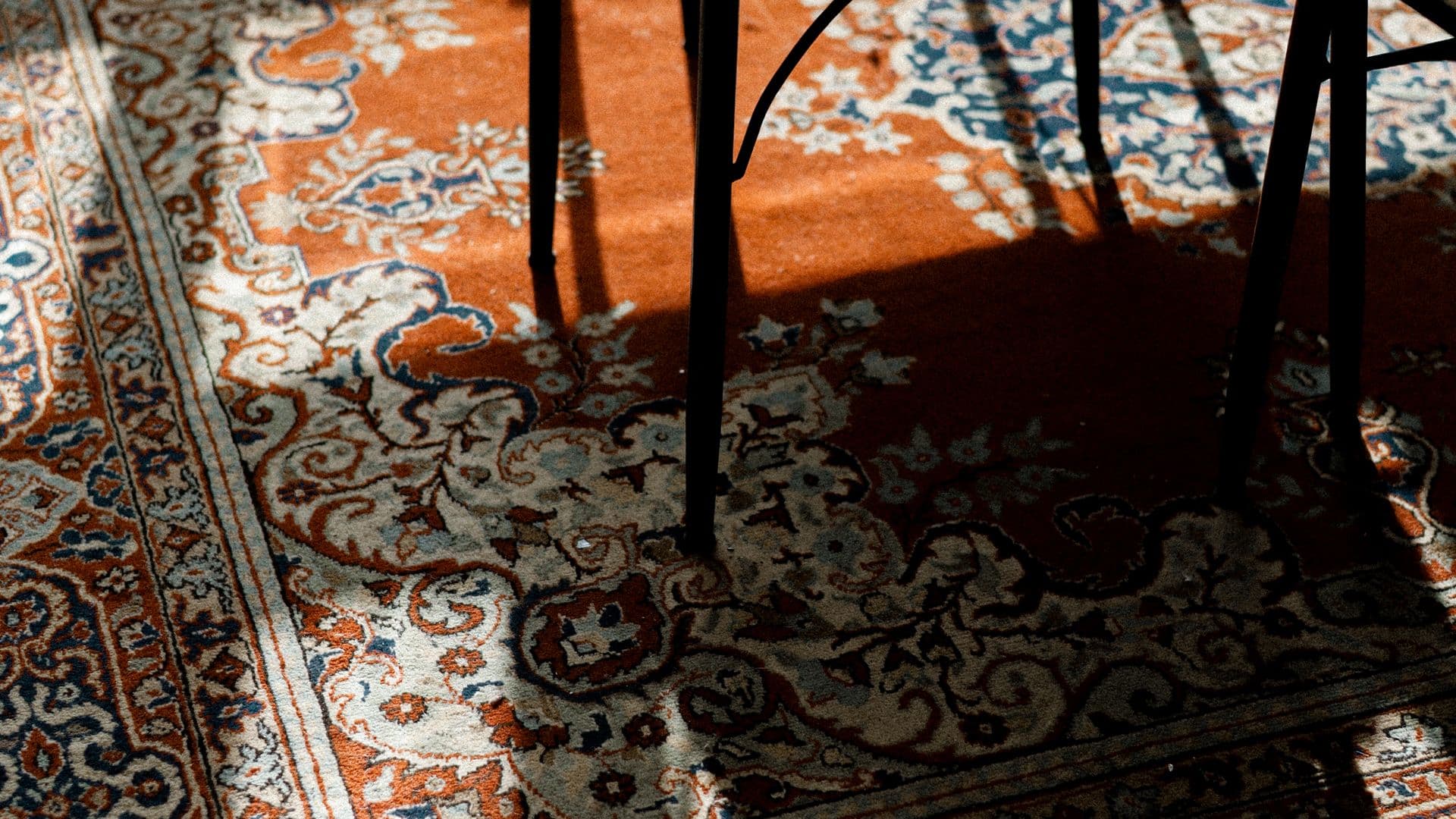 A hand-knotted Persian rug on the floor of a sunlit room