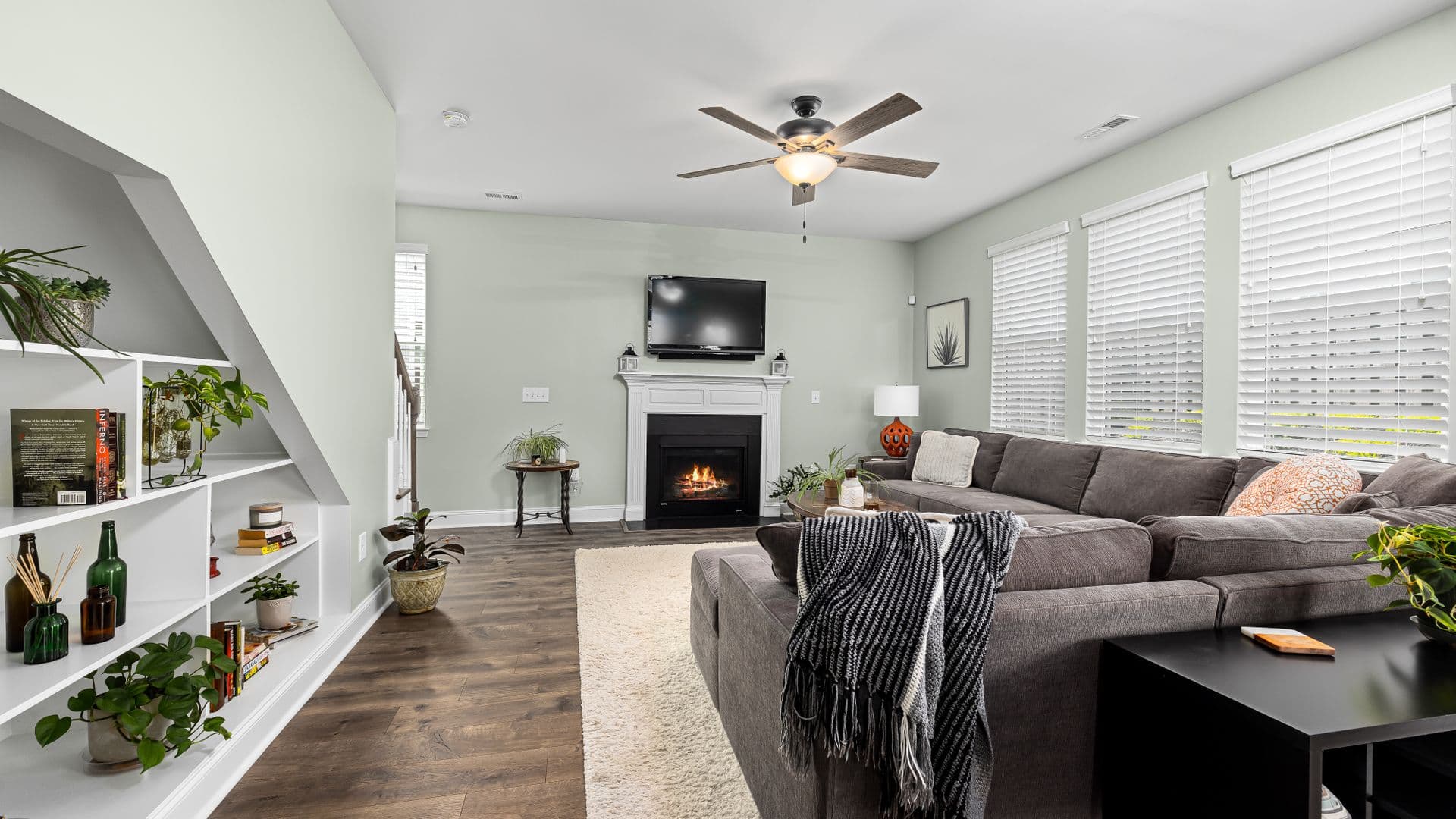 A living room with a large sectional sofa, armchairs and a fireplace