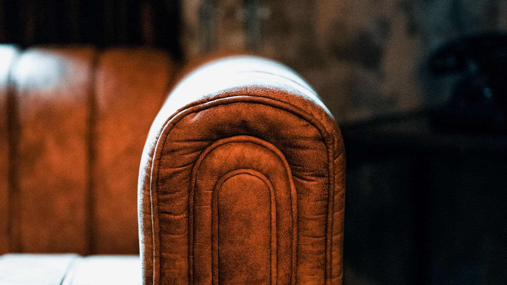 Close-up of a worn leather sofa armrest
