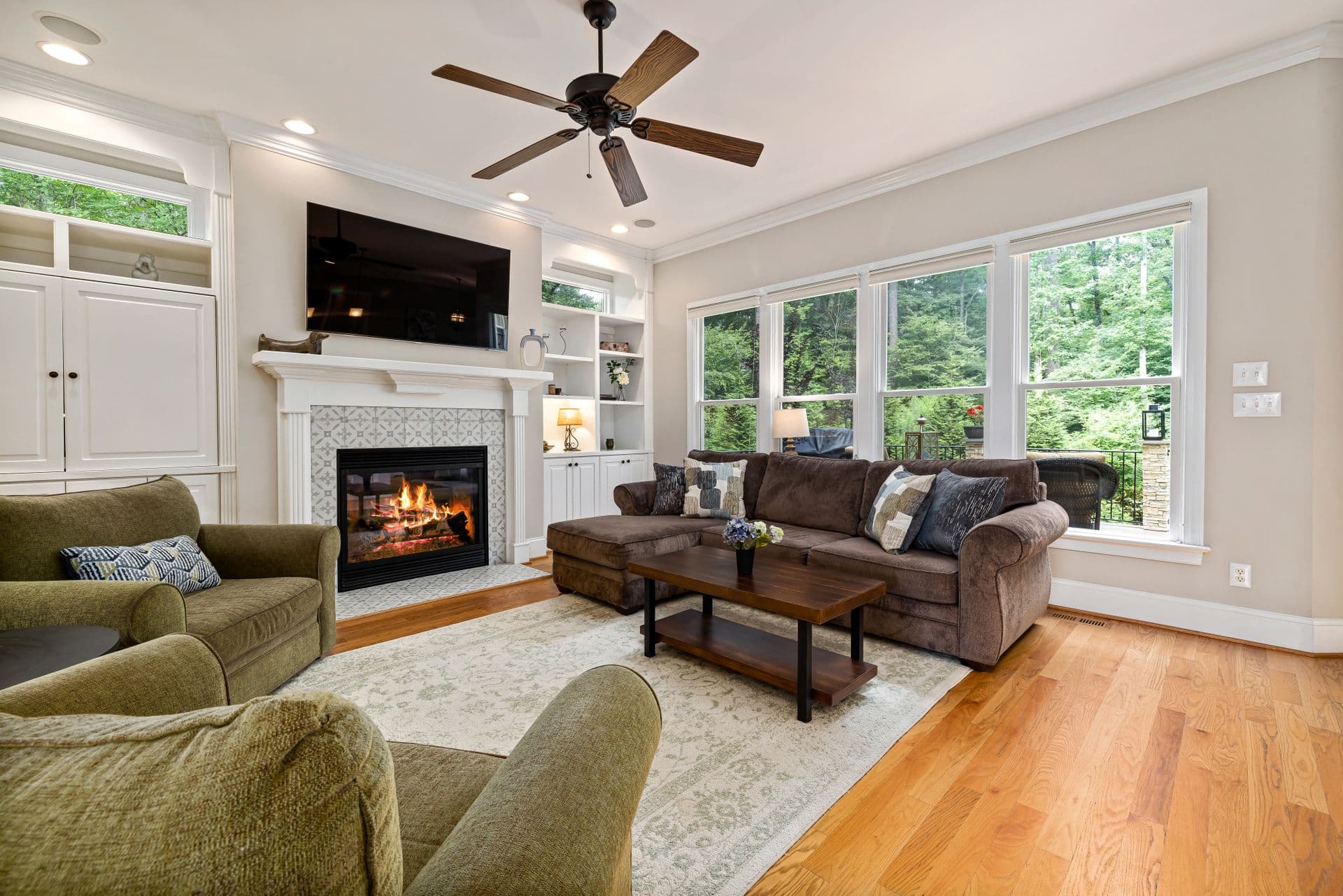 A living room set of a sofa and two armchairs arranged on a pale patterned rug